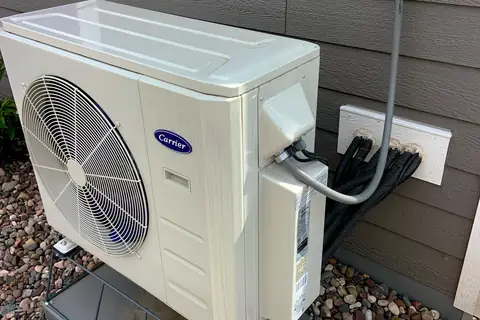 Unité extérieure de pompe à chaleur air-eau installée contre une maison